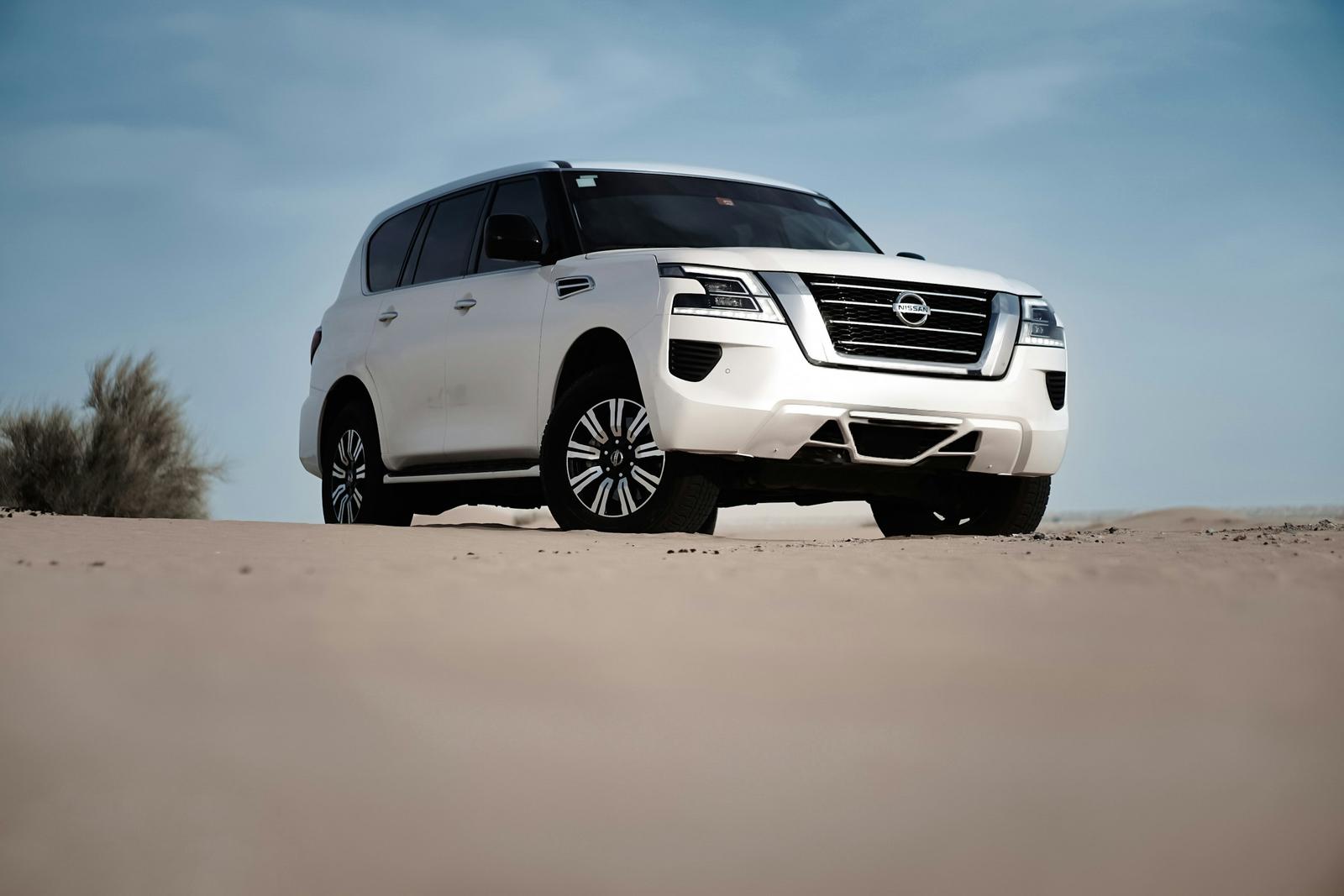 A white Nissan Patrol on desert sand